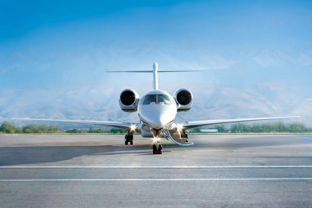 A private jet on the apron with mountains behind