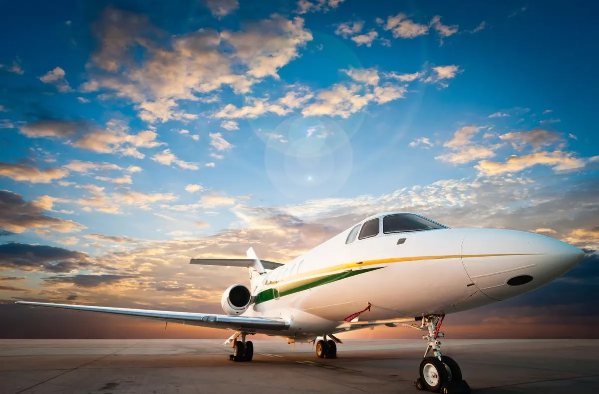 A private jet on the apron under a golden sky