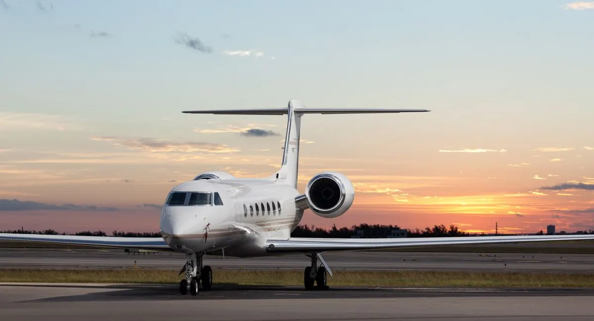 A private jet on the runway at sunset